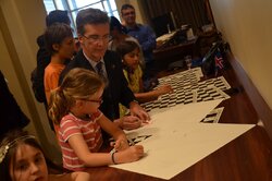 Signing the special gift Chess for Dialogue chess boards by children and permanent representatives.